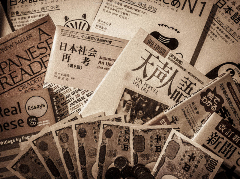 Combien pour parler japonais ? illustré par des livres et de l'argent japonais.